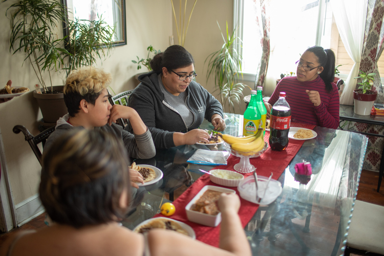 Julissa Robledo (on right) connects with Eleanor Moreno, Angel Robledo-Jimenez, and Maria Moreno-Reyes over a home-cooked meal.