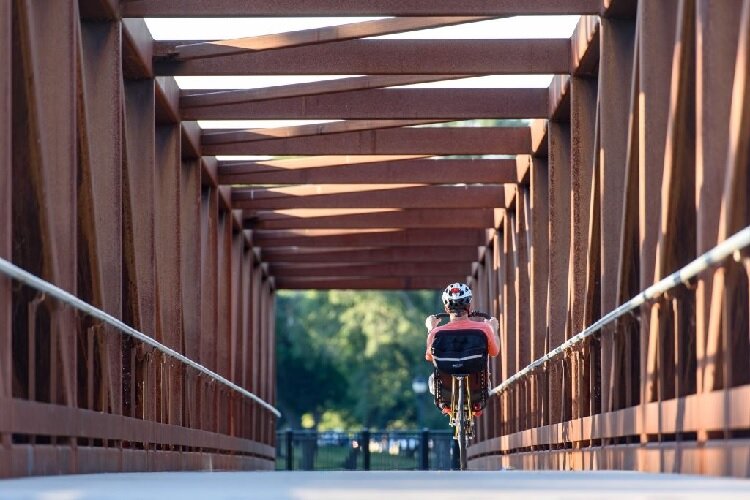 A recumbent bicyclist rides over a bridge on the B2B Trail.