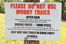 A sign warning cyclists to stay off the trail during the spring thaw.