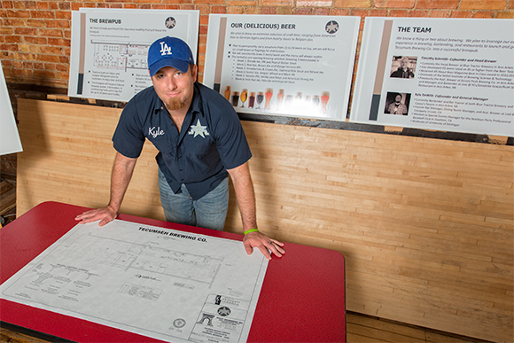 Kyle DeWitt with the blueprints for Tecumseh Brewing Company
