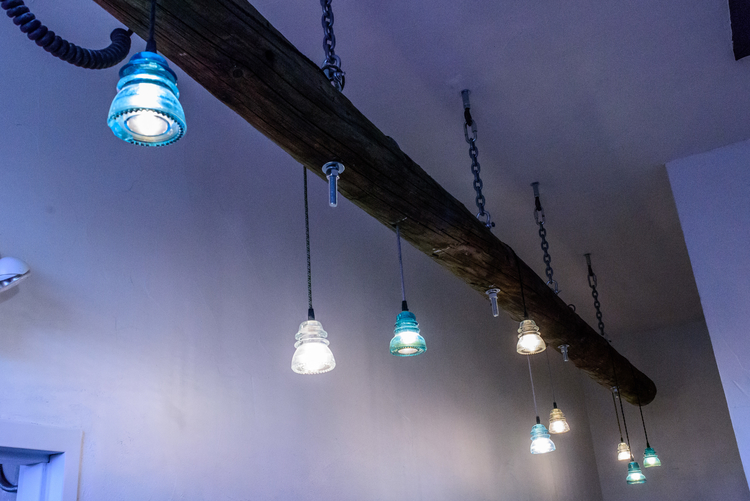 A light fixture at Landline Creative Labs constructed from a telephone pole and glass telephone line insulators.