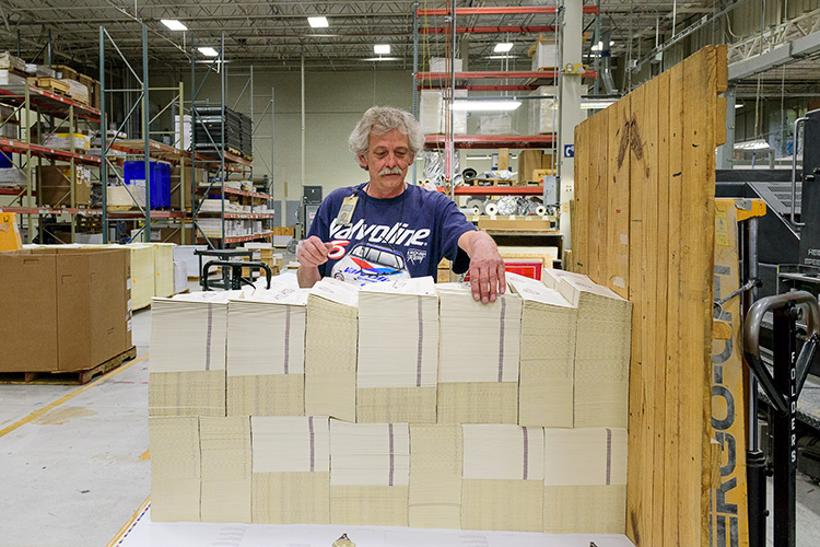 George Clickner stacking books coming off the presses at Thomson-Shore