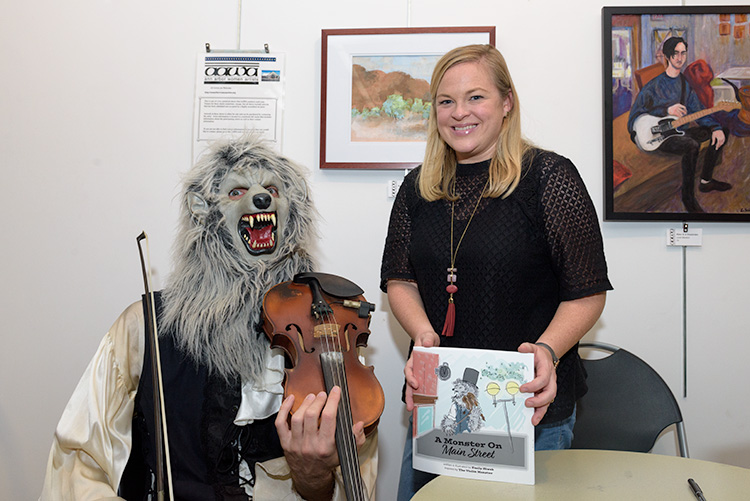 Violin Monster and author Emily Siwek with the picture book A Monster on Main Street
