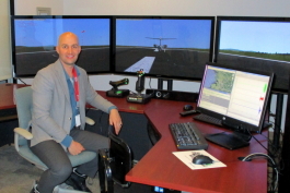 ADI CEO Scott James with ADI's flight simulator behind him.