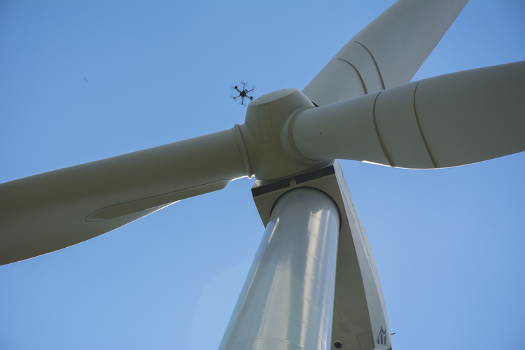 A SkySpecs drone inspects a wind turbine.