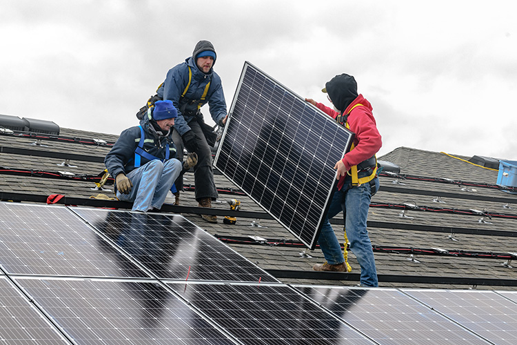 Installing solar panels on the Amos Washington Building at New Parkridge