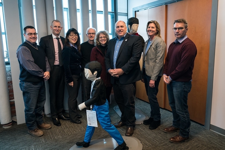 ACM team members pose with a pedestrian test dummy.