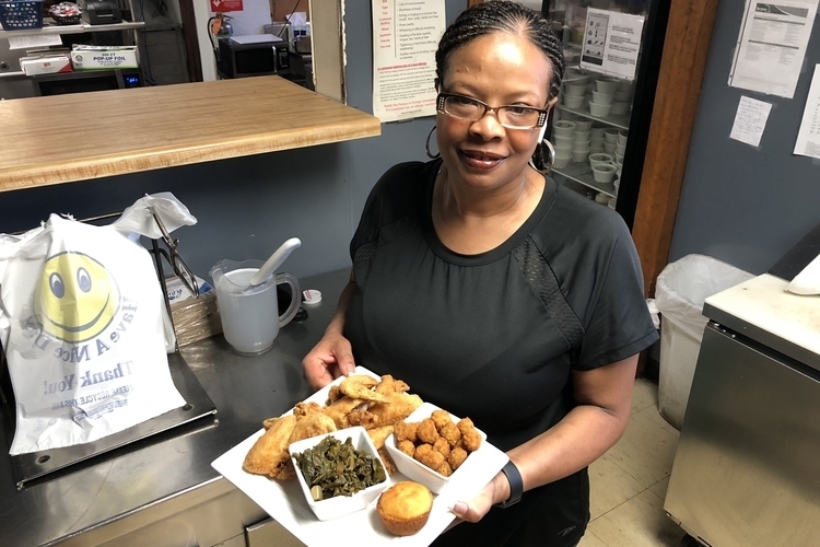 Andrea "Cuppy" White shows off a plate of food at Cuppy's Best Soulful Cafe.