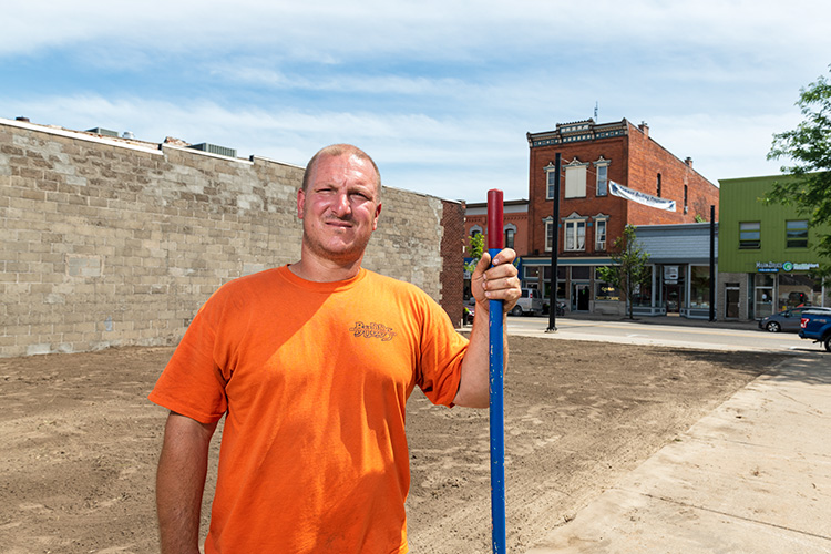Dan Budd prepares to lay sod for a pocket park at the former Danube Inn site in downtown Milan