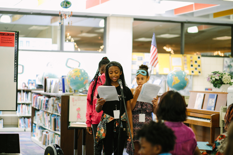 Student writer TaNiyah Lockley speaks at the book release party, as Keymani Barfield and Lilo Gatzke look on.