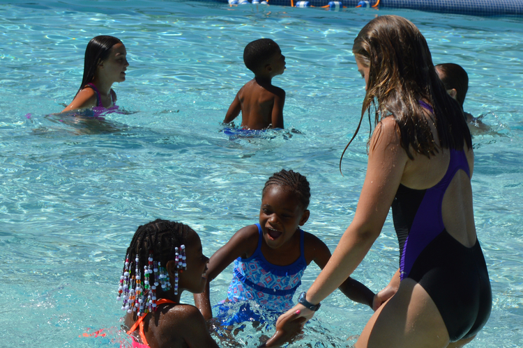A junior lifeguard teaches girls to swim at Rutherford Pool.