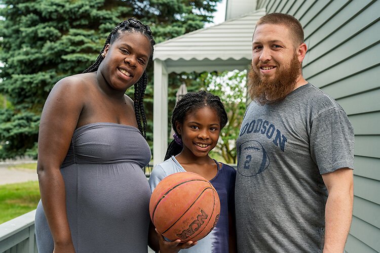 Adriya Perry, her daughter Akavayia, and husband Phil outside their new home in Ypsilanti Township.