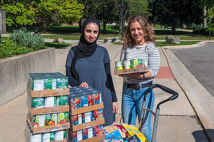 Sara Ajeen and Eliza Caughey unloading food for Swoop's Pantry at EMU.