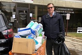 Michael Williams, director of the EMU School of Nursing, stands with items collected for donation to St. Joseph Mercy Health System.