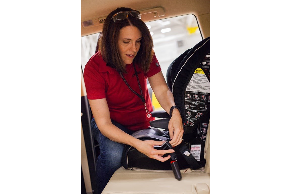 Toyota Principal Engineer Jennifer Pelky installs a car seat.