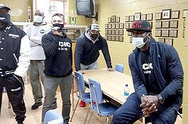 Michael Vick talks to press in the Trophy Room at Ypsilanti Community High School on Dec. 2 before addressing students in the auditorium.