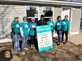 Habitat for Humanity homeowner-to-be Regina Young (center) stands with Women Build volunteers who are working on her future home.