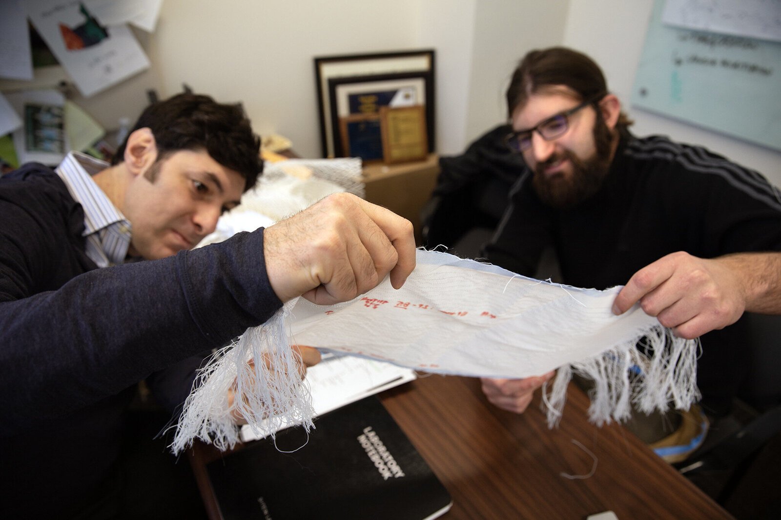 U-M Professor of Materials Science and Engineering Max Stein and Brian Iezzi, post-doctoral researcher at U-M's Materials Science and Engineering Department, analyze fabric with photonic fibers woven into it.