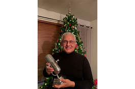 Rudy Alvarado with the trophy he won from the Latin Podcast Awards.