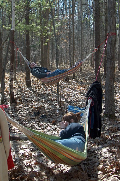 A group of friends unwind in hammocks at Deerfield Nature Park—this riverfront natural area also offers hiking and biking trails, two disc-golf courses, and areas for camping and fishing.
