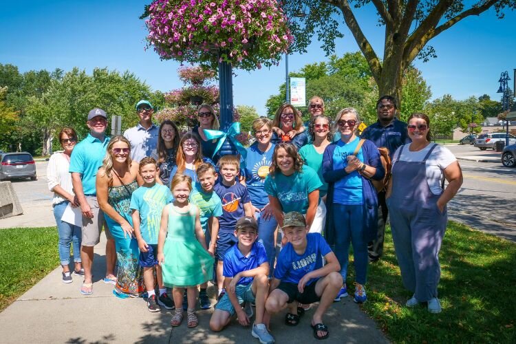 A group of volunteers participates in Tie Michigan Teal in downtown Mt. Pleasant on September 1, 2023.