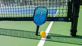 Pickleball is played with a racket and a wiffle-style ball.
