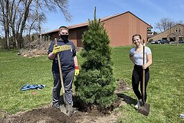 Two Mount Pleasant Middle School eight-graders pose with a tree they helped plant.