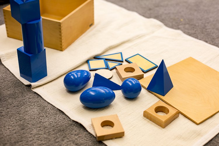 Montessori classrooms use specialized materials like wooden blocks to teach math and other concepts.