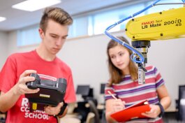 Kyle Gilber and Carsyn Boggio work in the Robotics Lab at the Academies at Romeo.