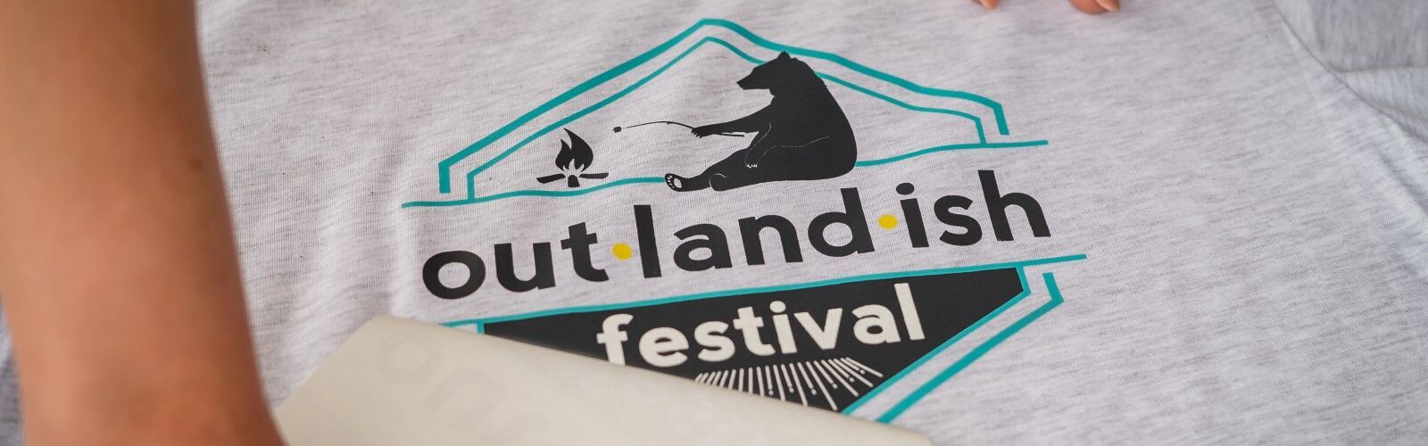 out·land·ish festival t-shirts being printed by Red Threads