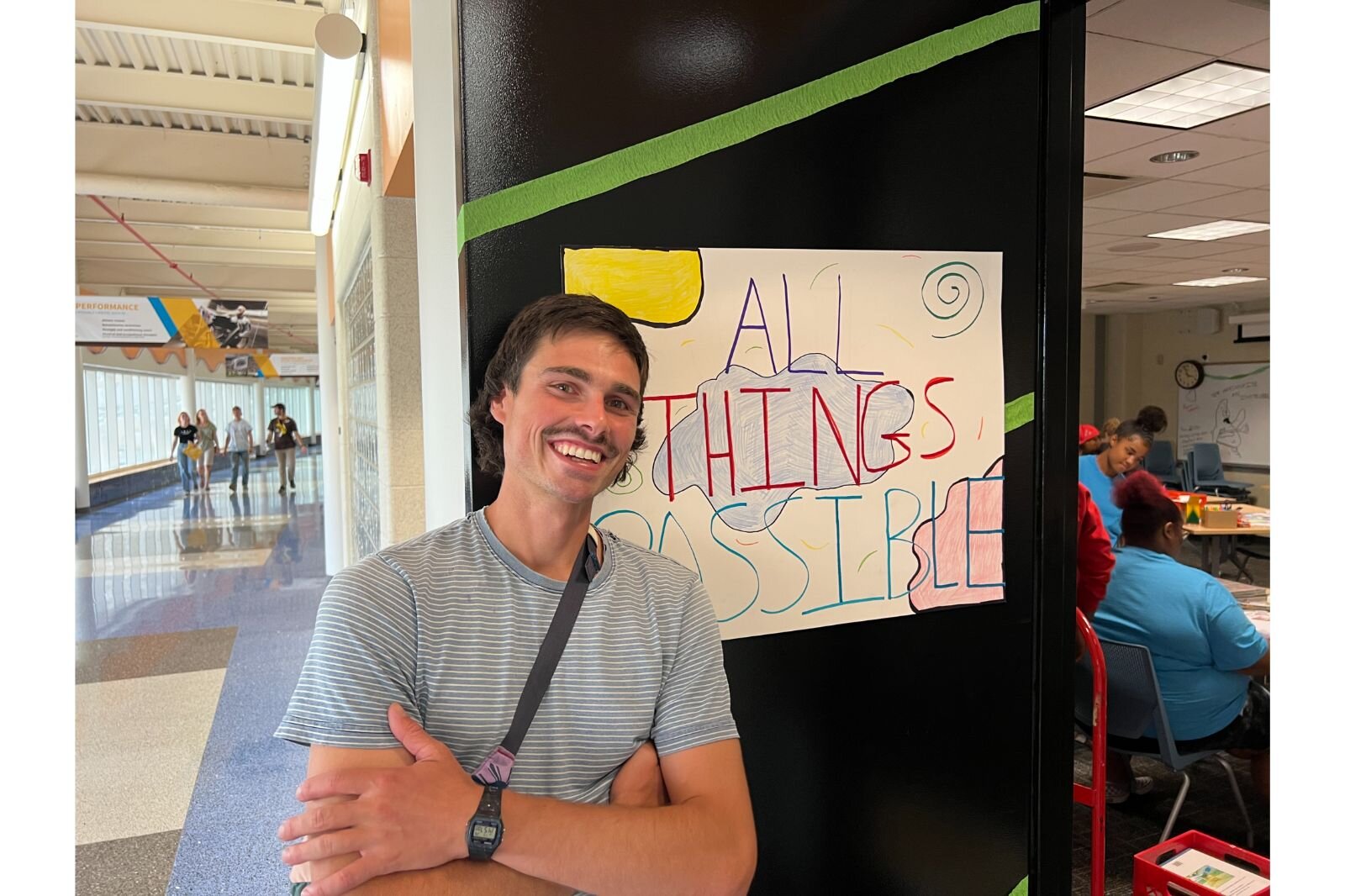 Erik Vasilauskas is all smiles in front of the All Things Possible sign. 