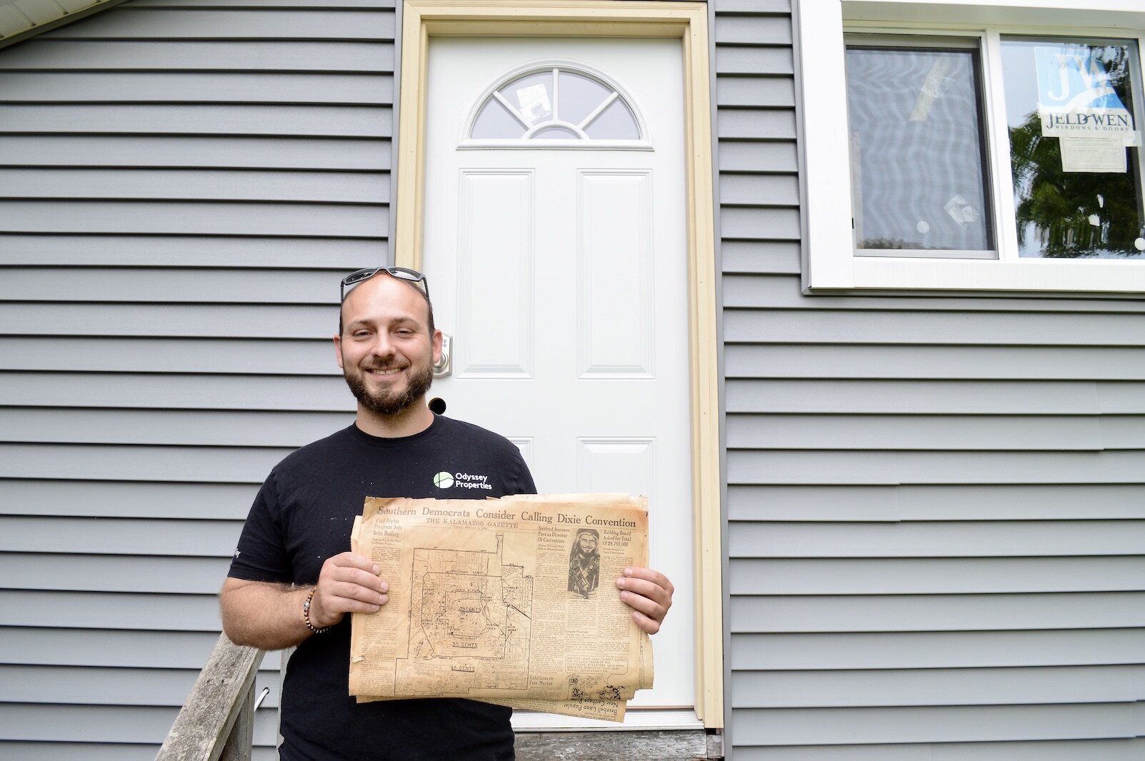 Jake Tardani with a 1948 Kalamazoo Gazette. He discovered a stack of papers going back to World War II at 1028 Denner. He says he appreciates the history and connections with Kalamazoo these old houses represent.  