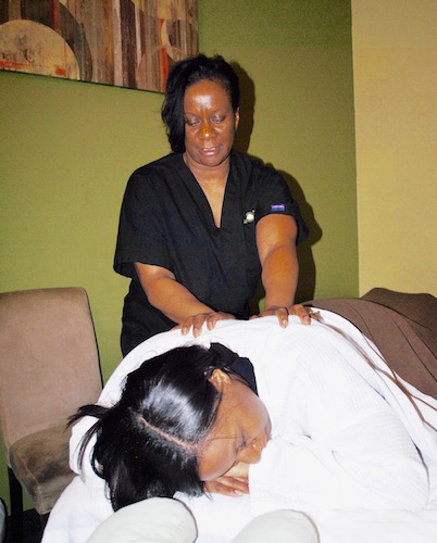 Margaret Kirk, owner of Massage Green SPA, gives her daughter, Tyla Wade, a shoulder massage in early February.
