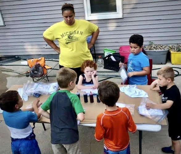 Danielle Buckmaster is shown helping neighborhood youngsters make tie-dyed shirts.