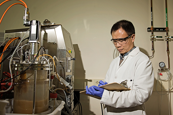 Lin Bau, Senior Research Scientist, checks a fermenter used to synthesize peptides.
