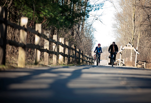 Melanie Brothers, left, and Paul Schnieder  bike down the trail near Celery Flats in Portage, MI