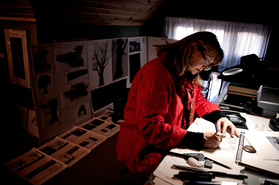 Linda Rzoska, owner of Ninth Wave Studio, works on a recent piece in her upstairs workspace.