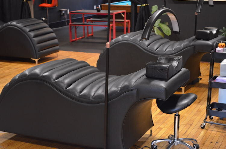 The black comfy salon tables that were designed specifically for comfort, and for different body and ability types. The salon area of AllyKat Studios