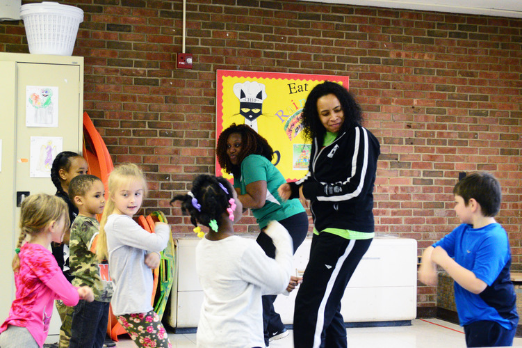 Operation Fit’s Mariama Wurie and Tamera Gibbs doing the ”Cha-Cha Slide” with LaMora kindergarteners. Photo by Mark Wedel