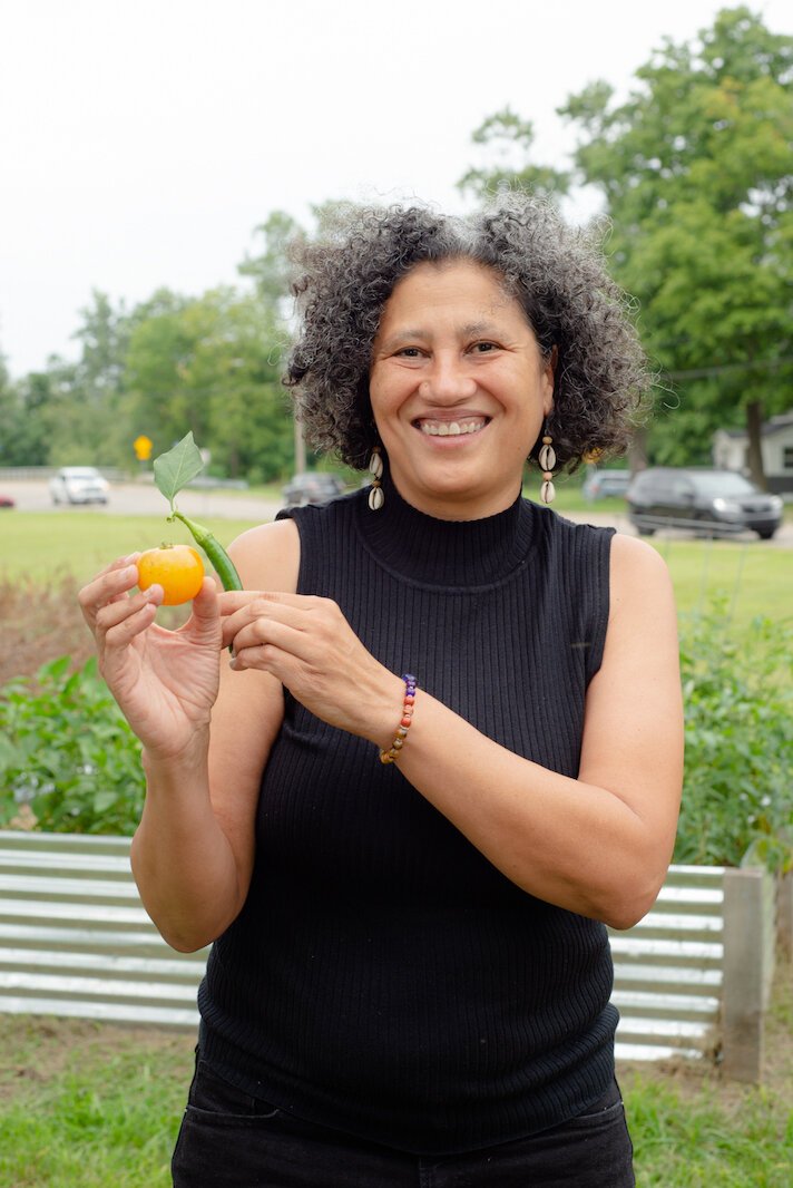 Dr. Michelle Johnson, Playgrown CEO, is seen here with a tomato and a pepper.