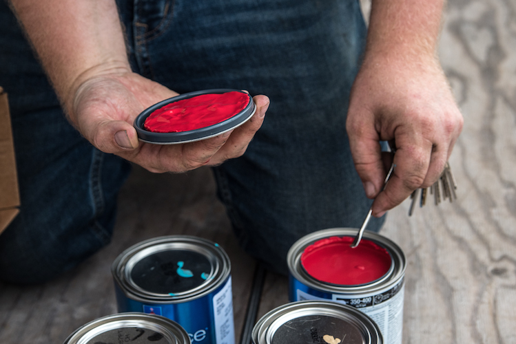 Patrick Hershberger mixes his paints for a new mural going up in the neighborhood. Photo by Fran Dwight