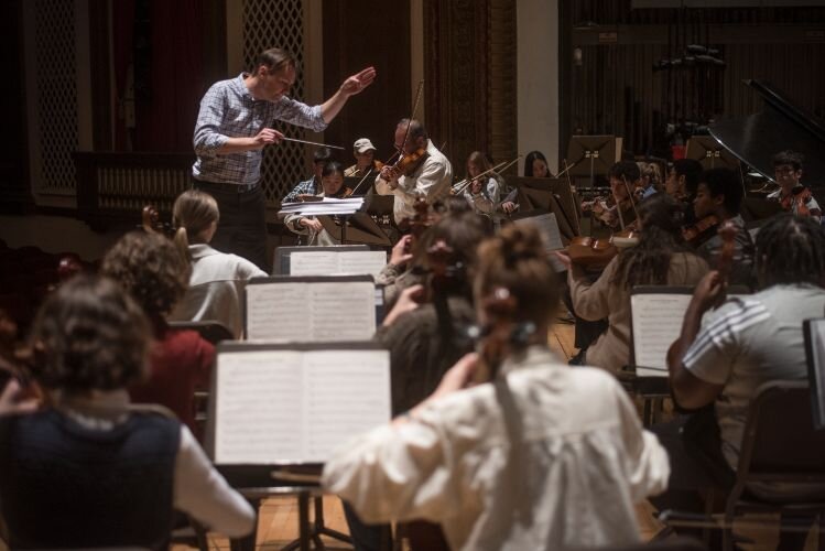 KJSO Conductor Andrew Koehler helps the orchestra musicians prepare for accompanying Mitchell Newman on a concerto for the unhoused.