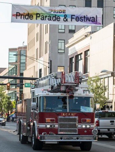 A fire truck passes under a banner during a recent Pride Month parade.