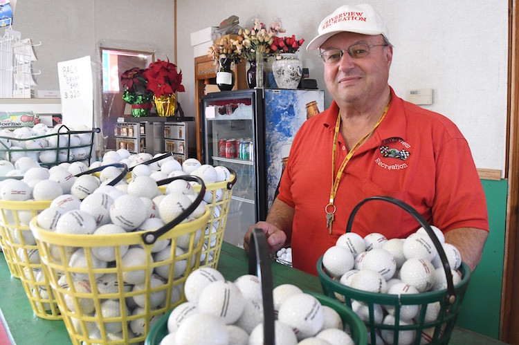 Jeff Heppler with buckets of golf balls for driving range.