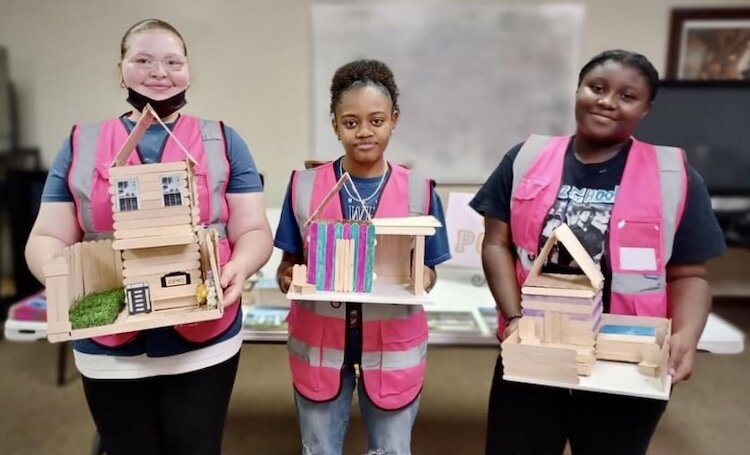From left, Rayah Jones, Kennedy Lockett, and Amit Bigby show houses they crafted from popsicle sticks as part of Girls Build Kalamazoo.