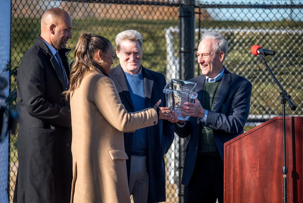 Harold Himmelman, chairman of the Cal Ripken Sr. Foundation awards Sharlee and Derek Jeter on Nov. 14, 2023, for their commitment to helping youth. In the background is Foundation CEO Steve Salem.