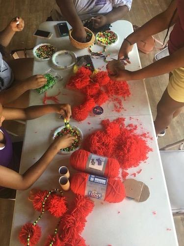 Rootead Youth Dance Company preparing for a show by creating and designing their own unique African Dance belts and accessories. 