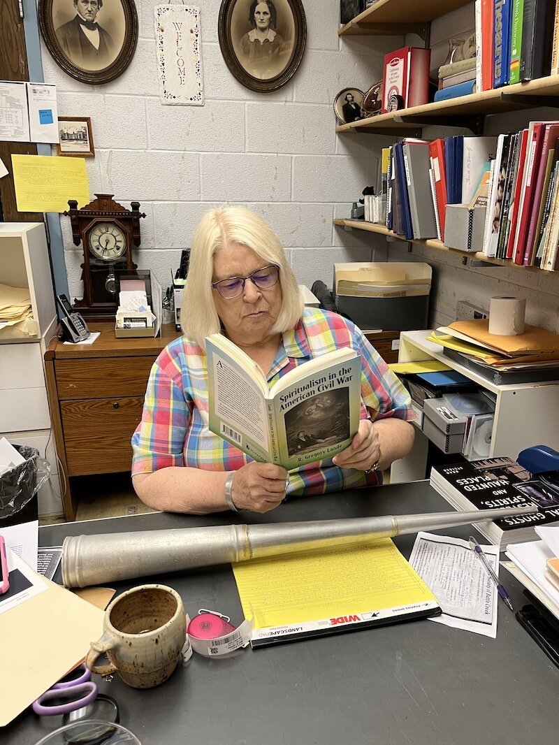Jody Owens, a volunteer with the Battle Creek Historical Society, reads a book about Spiritualism and the Civil War.  Owen says people who lost loved ones during the war gravitated towards spiritual mediums to try and contact those who had died.