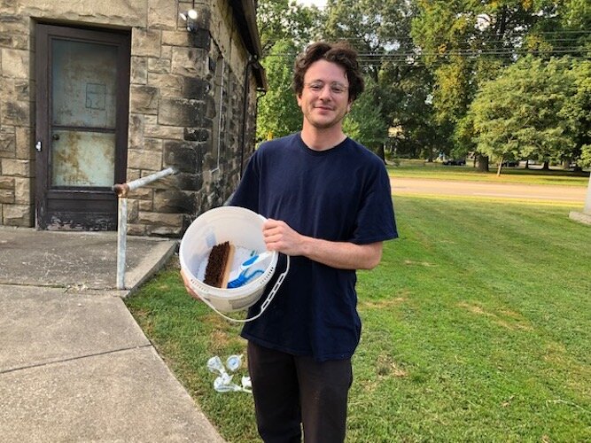Luis Peña, historic preservation coordinator with the city of Kalamazoo, was down to the last bucket of supplies for volunteers who turned out recently to scrub gravestones at Mountain Home Cemetery.