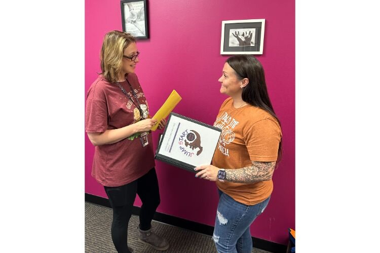 Kelley Parish, at left and Courtney Berger, at right, take a moment to check in with each other. Parish is Jumpstart's Certified Family Life Educator and leads the afterschool program, and Berger is the Operations Manager.